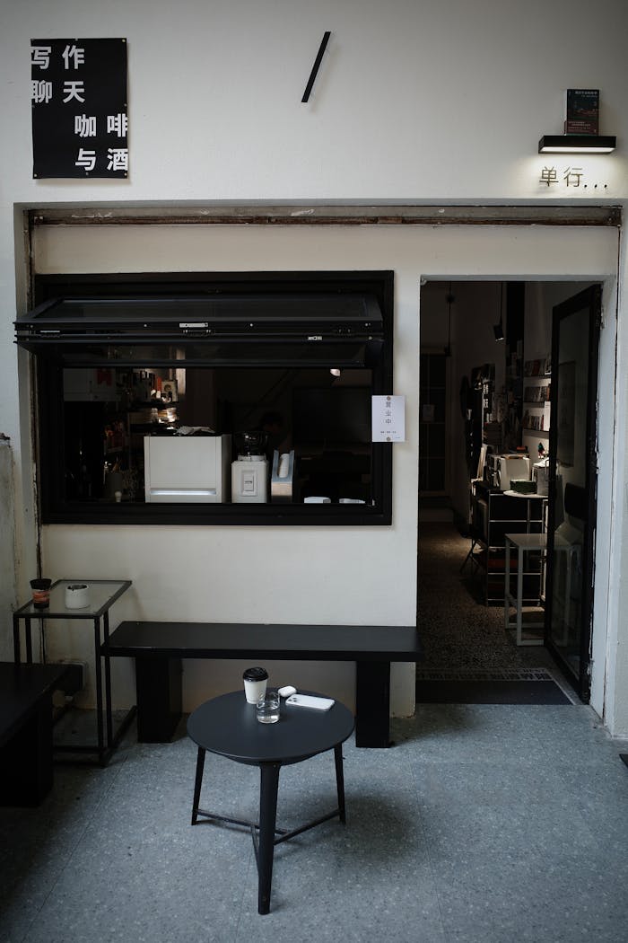 Cozy minimalist café in Chongqing, China. Simple design with a black table setting and creative signage.